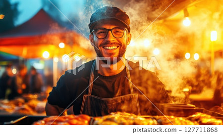 Smiling chef at outdoor food market serving grilled dishes during evening hours with vibrant lights and festive atmosphere 127711868