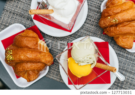 Croissant with pistachio and mango scoops of gelato in italian cafe Croissant with pistachio and mango scoops of gelato in italian cafe 127713031
