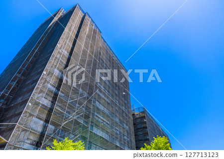 Yokohama cityscape in Japan. Apartment building repairs and inspections, scaffolding and protective nets. Satellite antennas outside the nets... Yokohama cityscape in Japan. Apartment building repairs and inspections, scaffolding and protective nets. Satellite antennas outside the nets... 127713123