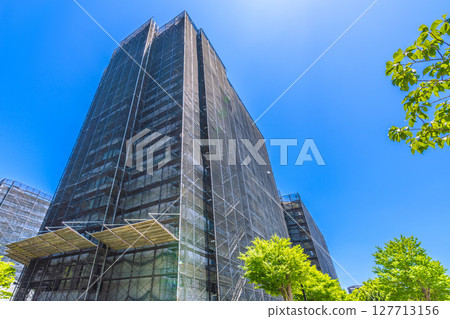 Yokohama cityscape in Japan. Apartment building repairs and inspections, scaffolding and protective nets. Satellite antennas outside the nets... Yokohama cityscape in Japan. Apartment building repairs and inspections, scaffolding and protective nets. Satellite antennas outside the nets... 127713156