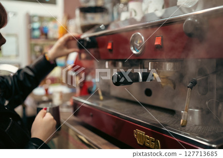 Female barista using modern coffee machine in cafeteria Female barista using modern coffee machine in cafeteria 127713685