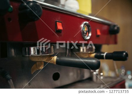 Female barista using modern coffee machine in cafeteria Female barista using modern coffee machine in cafeteria 127713735