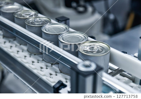 Canned food products on conveyor belt in distribution warehouse. parcels transportation system concept Canned food products on conveyor belt in distribution warehouse. parcels transportation system concept 127713758