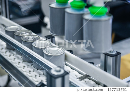 Canned food products on conveyor belt in distribution warehouse. parcels transportation system concept	 127713761