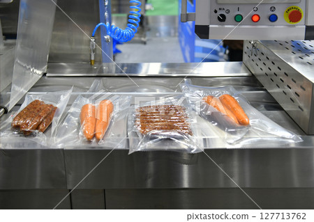 High-performance machines are wrapping food products food in production lines on conveyor belts, food production industry High-performance machines are wrapping food products food in production lines on conveyor belts, food production industry 127713762