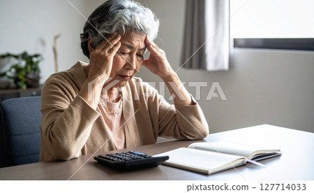 Senior woman worried about her household budget using a calculator Senior woman worried about her household budget using a calculator 127714033