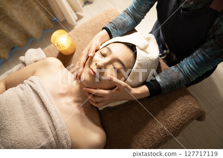 Woman receiving a facial massage Woman receiving a facial massage 127717119