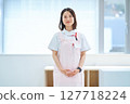 A woman in a white coat and apron 127718224