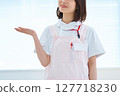 A woman in a white coat and apron 127718230