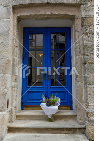 Charming Blue Door with Floral Arrangement and Stone Surrounding, Capturing the Essence of Urban Architecture and Natural Beauty in a Picture-Perfect Setting 127719317