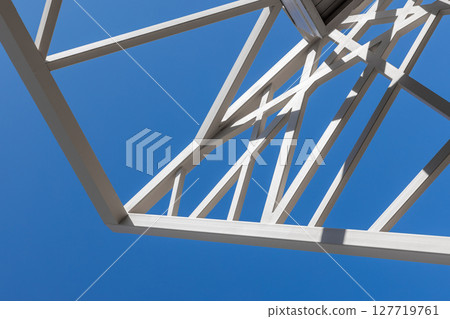 Metallic framework designed with geometric precision against blue sky Metallic framework designed with geometric precision against blue sky 127719761