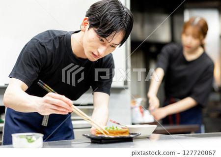 A man cooking at a bar 127720067