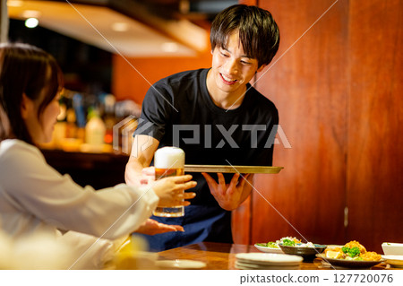 A man working part-time at an izakaya 127720076