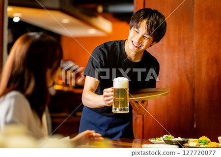 A man working part-time at an izakaya 127720077