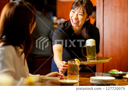 居酒屋裡一位女士正在為顧客服務 127720079