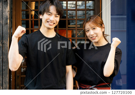 Male and female part-time workers standing in front of the store Male and female part-time workers standing in front of the store 127720100