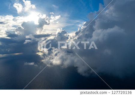 Dramatic sky with sunbeams and clouds seen from an airplane 127720136