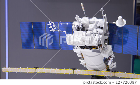 A detailed model of a military satellite, featuring solar panels and weapon systems, is showcased at a defense expo. A detailed model of a military satellite, featuring solar panels and weapon systems, is showcased at a defense expo. 127720387
