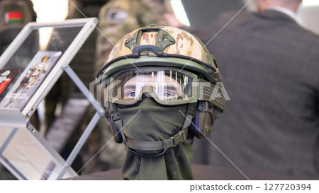 A mannequin wearing a camouflage military helmet exhibits cutting-edge technology designed for combat situations at a defense trade show. A mannequin wearing a camouflage military helmet exhibits cutting-edge technology designed for combat situations at a defense trade show. 127720394