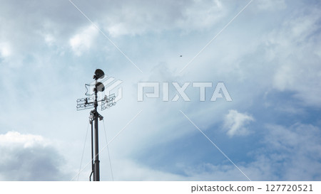 Surveillance equipment stands tall against a cloudy sky, focusing on communication efforts in a war zone, critical for military operations and intelligence gathering. Surveillance equipment stands tall against a cloudy sky, focusing on communication efforts in a war zone, critical for military operations and intelligence gathering. 127720521