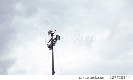 Communication equipment on a tall tower captures signals in a war area, ensuring coordination among forces while clouds gather ominously overhead. Communication equipment on a tall tower captures signals in a war area, ensuring coordination among forces while clouds gather ominously overhead. 127720544