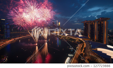 Colorful fireworks exploding over cityscape at night, illuminating skyline with vibrant colors and creating festive atmosphere 127723666