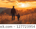 Father and son walk hand in hand during sunset in a peaceful field creating cherished moments together 127723954