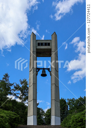Monumental brutalist concrete bell tower structure against a clear blue sky, evoking historical remembrance, lasting peace, and solemnity Monumental brutalist concrete bell tower structure against a clear blue sky, evoking historical remembrance, lasting peace, and solemnity 127724411