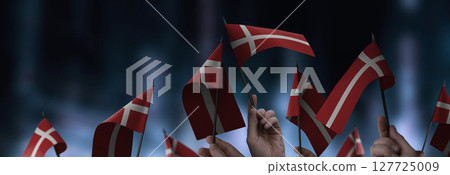 Denmark flags in their hands on a blurred urban background Denmark flags in their hands on a blurred urban background 127725009