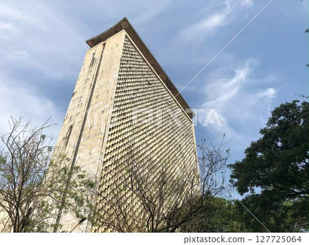 Vidhan Bhavan in Mumbai, India. Low angle view of a tall concrete building with geometric facade. Vidhan Bhavan in Mumbai, India. Low angle view of a tall concrete building with geometric facade. 127725064