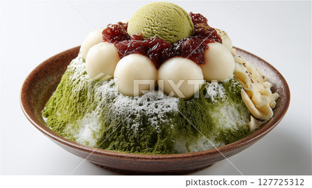 A Japanese-style dessert of matcha shaved ice topped with shiratama and bean paste 127725312