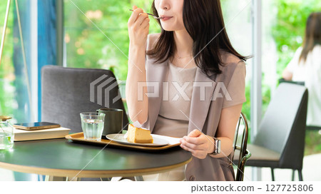 在咖啡館吃蛋糕的女人 127725806