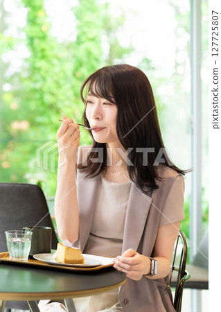 在咖啡館吃蛋糕的女人 127725807