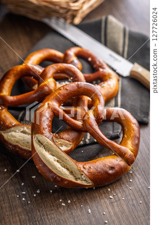 Salted bavarian pretzel on wooden table. Salted bavarian pretzel on wooden table. 127726024