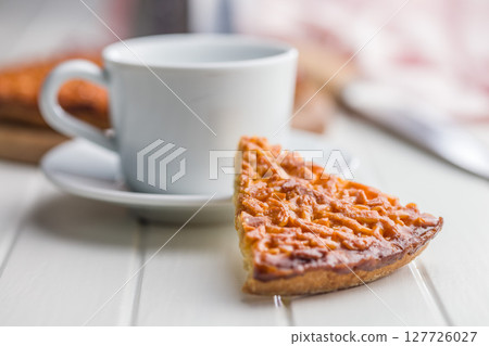 Sweet almond pie on white table. 127726027