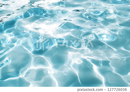 Light shimmers on the waves of clear blue water in a pool or sea. Selective focus, defocus 127726036