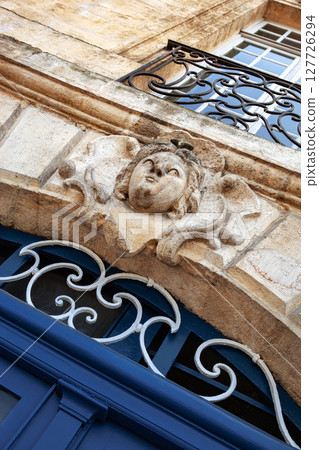 Mascaron sculpture on a stone wall Mascaron sculpture on a stone wall 127726294
