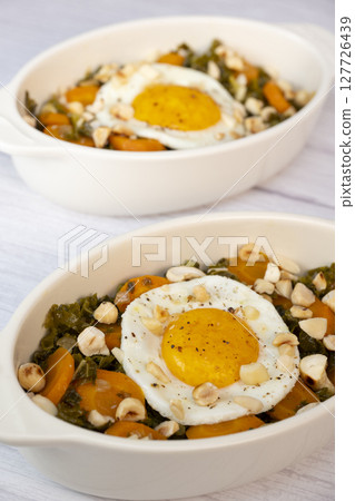 Recipe for kale, carrot and garlic poellee, chopped hazelnuts, cashews and almonds, and fried egg Recipe for kale, carrot and garlic poellee, chopped hazelnuts, cashews and almonds, and fried egg 127726439