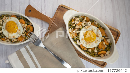 Recipe for kale, carrot and garlic poellee, chopped hazelnuts, cashews and almonds, and fried egg 127726442