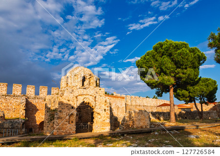 Ancient Byzantine church ruins with arched entrance and fortress wall in Alanya Castle at sunset 127726584