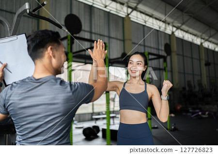 Personal Trainer and Client Engaging in Fitness Session 127726823