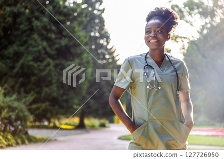 Portrait of medical worker standing in park with green background Portrait of medical worker standing in park with green background 127726950