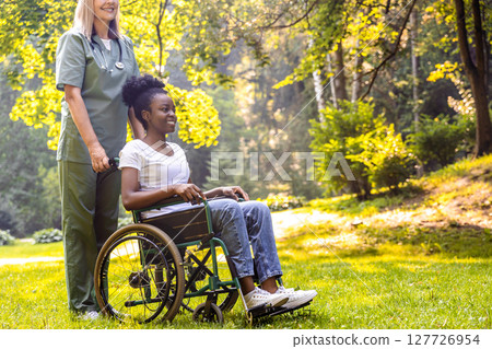 Caregiver supporting elderly in rehab exercise in park setting Caregiver supporting elderly in rehab exercise in park setting 127726954