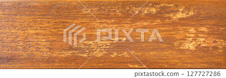 Close up of distressed orange wooden plank showing wood grain 127727286
