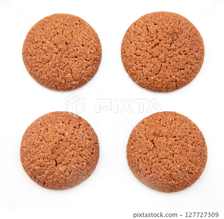 Four round chocolate cookies resting on white background 127727309