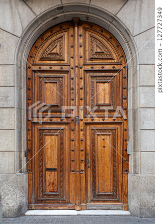 Elegant arched wooden door with greek key pattern inviting entry Elegant arched wooden door with greek key pattern inviting entry 127727349