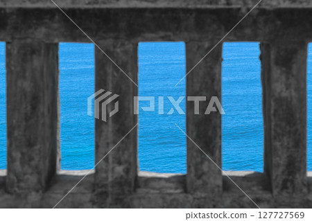 Blue Indian ocean visible through old ancient temple wall in Bali island, Indonesia. Ocean is in camera focus Blue Indian ocean visible through old ancient temple wall in Bali island, Indonesia. Ocean is in camera focus 127727569