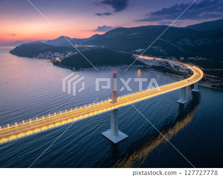 Aerial view of modern Peljesac bridge and blue sea at night 127727778