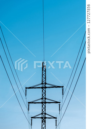 High voltage electricity transmission metallic pole dark silhouette 127727856