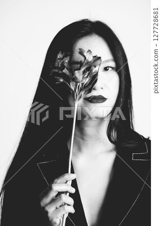 Black and white Asian woman portrait cover her one eye with flower Black and white Asian woman portrait cover her one eye with flower 127728681
